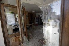 Damaged houses are reflected in the shattered window of a cafe, in Accumoli, central Italy, Wednesday, Aug. 24, 2016. The magnitude 6 quake struck at 3:36 a.m. [0136 GMT] and was felt across a broad swath of central Italy, including Rome where 
residents of the capital felt a long swaying followed by aftershocks. AP Photo/Andrew Medichini
