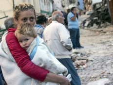 A woman holds a child as they stand in the street following an earthquake, in Amatrice, Italy, Wednesday, Aug. 24, 2016.  The magnitude 6 quake struck at 3:36 a.m. [0136 GMT] and was felt across a broad swath of central Italy, including Rome where residents of the capital felt a long swaying followed by aftershocks. Massimo Percossi/ANSA via AP