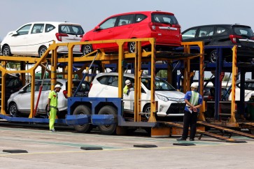Workers load cars onto a truck at the Astra Daihatsu Motor (ADM) car factory in Karawang, West Java, on August 2019.
