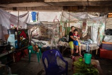 Sri Lestari, 31, live together with his husband Benny Putra, 33, and sons Valerino, 4, and Dedy Putra, 3, in her shack, Pejagalan, Jakarta, August 2016. They had been living there since 2002. They work as a clothes vendor at several night markets. JP/Seto Wardhana