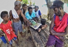 People of the Kamoro tribe read a newspaper in Kampung Lakahia, Kaimana. JP/Wendra Ajistyatama