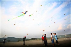 Visitors of the 2016 National Kite Festival observe kites flying in the skies of Parangkusumo Beach in Bantul, Yogyakarta. JP/ Aditya Sagita