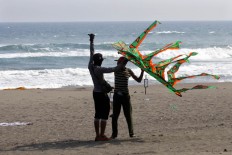 Two men try to fly the two dimensional kite at the 2016 National Kite Festival on Parangkusumo Beach in Bantul, Yogyakarta. JP/ Aditya Sagita
