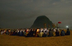 People participate in a prayer ritual in view of Pulau Merah. JP/Tarko Sudiarno
