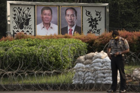 A policeman stands near photos of President Joko "Jokowi" Widodo and Philippine President Rodrigo Duterte displayed outside the State Palace on Sept. 8. Duterte will visit Jakarta for a bilateral meeting on Sept. 9