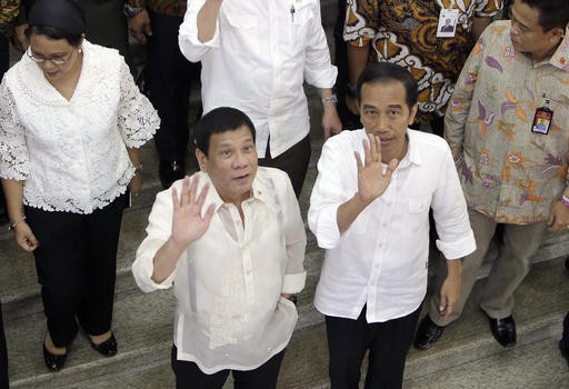 Philippines' President Rodrigo Duterte, center left, waves with his Indonesian counterpart Joko Widodo during their visit at Tanah Abang Market on the sidelines of their meeting in Jakarta on Sept. 9. Duterte is currently on a two-day visit to the country. 