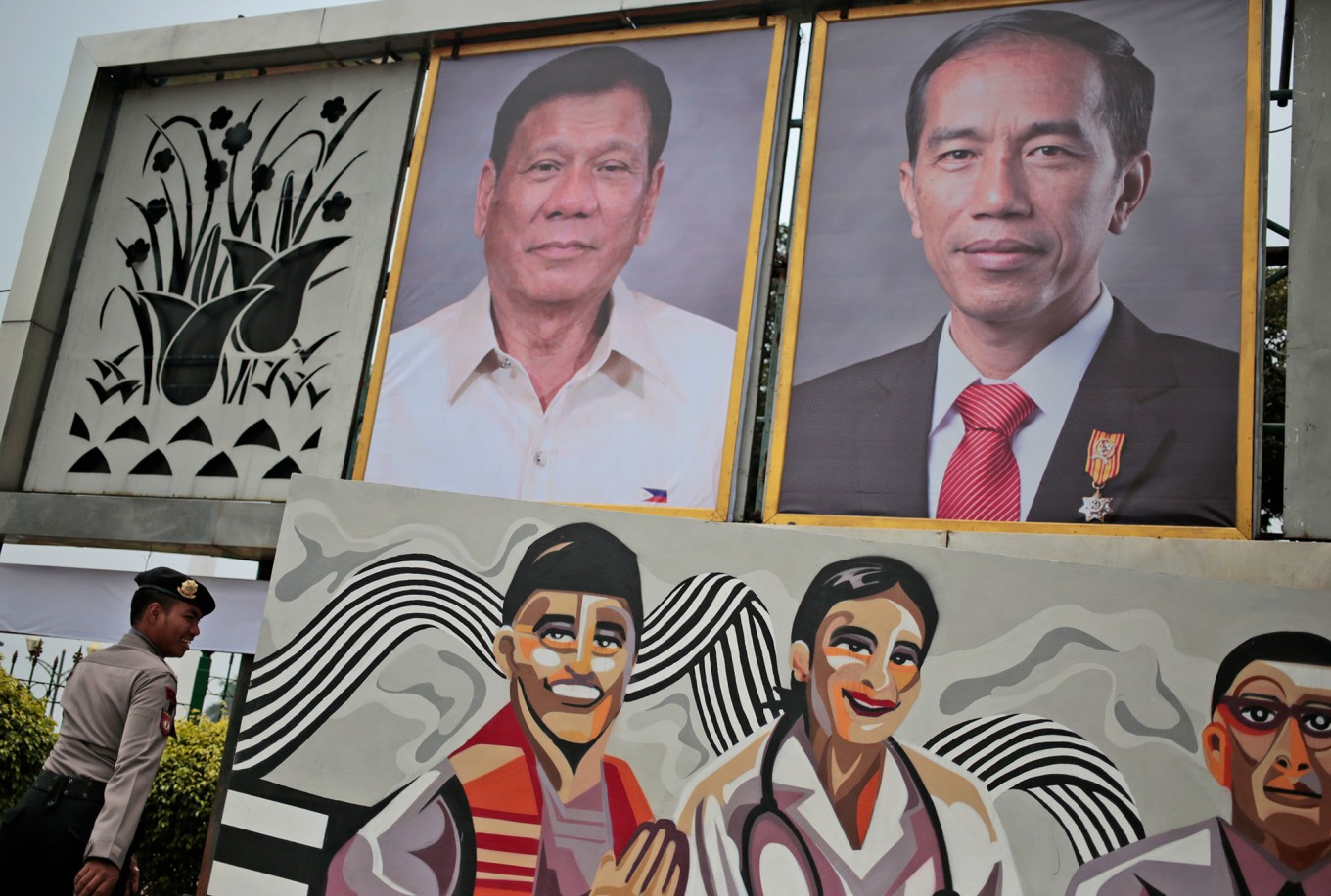 An Indonesian police officer walks past large portraits of Philippines' President Rodrigo Duterte, left, and his Indonesian counterpart Joko Widodo outside the presidential palace in Jakarta, Indonesia, Thursday, Sept. 8, 2016. The portraits are put up as a part of the preparations of the meeting of the two leaders in the capital city on Friday. 