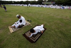 Two boys and a father lie on their prayer mats after conducting Idul Adha prayers in Banda Aceh on Sept. 12. JP/ Hotli Simanjuntak