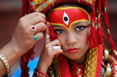 A Nepalese mother applies make up to her daughter dressed as the living goddess Kumari as they wait for Kumari puja to start at Hanuman Dhoka temple, in Kathmandu, Nepal, Wednesday, Sept. 14, 2016.