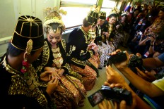 Couples put rings on their respective spouses onboard the Prambanan Express after exchanging vows at a mass wedding event in Yogyakarta on Sept. 6. JP/ Aditya Sagita