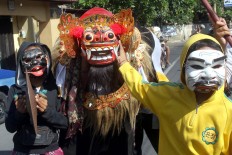 Children wear masks and walk around their village to perform a tradition called Ngelawang Barong, accompanied by gamelan, at Banjar Bungkak, Denpasar, Bali. JP/Zul Trio Anggono