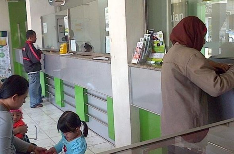 People make financial transactions at a branch office of state-owned pawnshop Pegadaian in Semarang, Central Java, in this file photo from 2015.