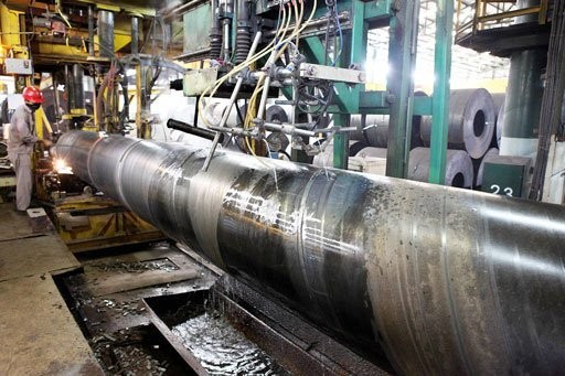 An employee finishes production of steel pipes in this undated photograph at the Krakatau Steel plant in Cilegon, Banten.