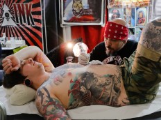 In this picture taken on Sunday, Oct. 16, 2016, a man gets a tattoo during the International Tattoo Convention Bucharest 2016 in Bucharest, Romania. More than 100 tattoo and piercing artists brought their skills and art to a three-day convention in the Romanian capital. AP Photo/Vadim Ghirda