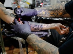 In this picture taken on Sunday, Oct. 16, 2016, Paul Booth of the U.S., one of the world's most famous tattoo artists, works during the International Tattoo Convention Bucharest 2016 in Bucharest, Romania. AP Photo/Vadim Ghirda