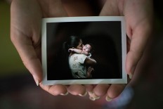 In this Sept. 26, 2016 photo, Angelica Pereira holds a instant film photo of her and her daughter Luiza, who was born with microcephaly, one of many serious medical problems that can be caused by congenital Zika syndrome, in Santa Cruz do Capibaribe, Pernambuco state, Brazil. For a brief moment, mothers with 1-year-old babies with microcephaly, forgot about getting that hard-to-find drug needed to prevent their babies from having seizures or the uncomfortable stares directed at their children born with small heads because of a Zika virus infection in the womb. Instead they were just like any other moms getting the first formal photographs of their babies. AP Photo/Felipe Dana