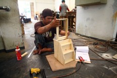 A craftsman makes a miniature vanity table at the Mandiri Craft workshop. JP/Aditya Sagita
