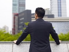 An office worker looks out from a balcony. Businesspeople in Indonesia are the most optimistic about revenue growth in the next 12 months, according to a recent survey by Grant Thornton in 29 countries.