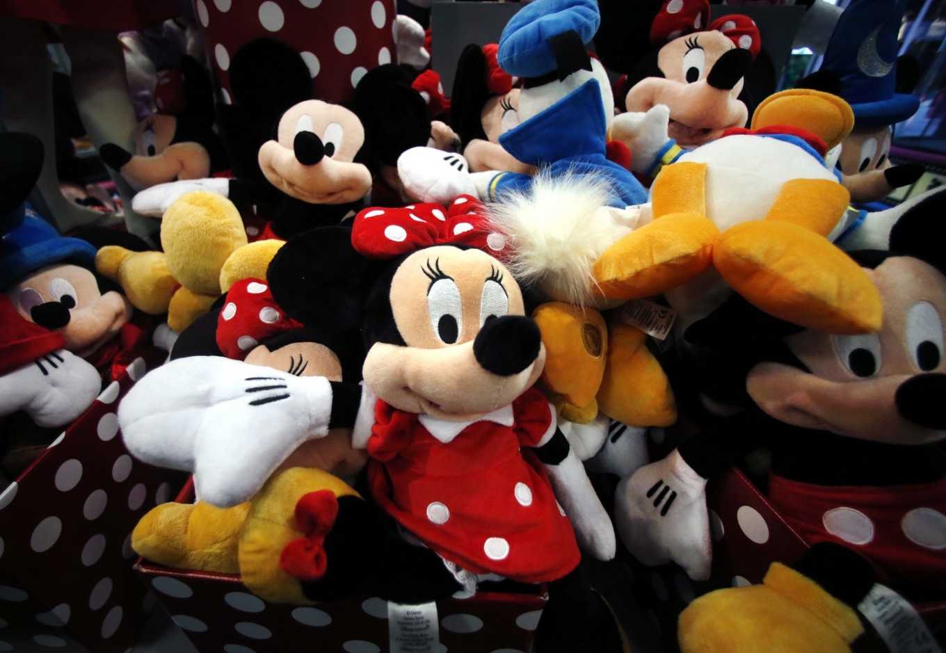 This Jan. 31, 2014, file photo shows plush Disney characters piled up in a display at a Disney Store in Saugus, Mass. As more and more people get their favorite TV shows and movies online, Disney is also learning to embrace the stream. The company once resisted offering channels like ESPN directly over the internet, preferring old-fashioned cable subscriptions. But Disney, which owns Marvel, Star Wars and its own Pixar and Disney Studios, is forging ahead with new streaming deals involving Netflix, Hulu and others.