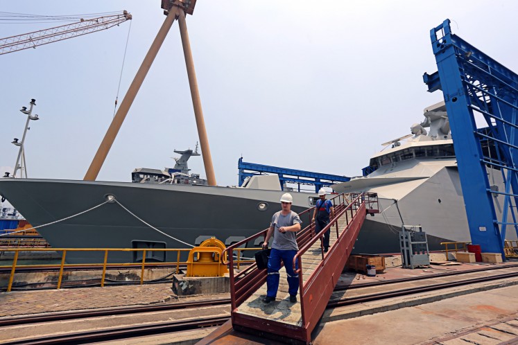Foreign technicians walk down the gangway of the KRI I Gusti Ngurah Rai warship at the shipyard of state-owned shipbuilder PT PAL Indonesia in Surabaya, East Java, on Nov.8, 2016.
