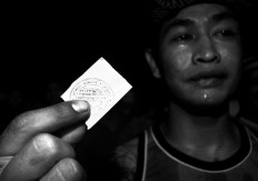 A fighter holds up his coupon entitling him to a plate of chicken soup and rice. JP/ Aman Rochman