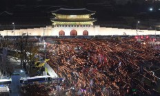 Tens of thousands of South Korean protesters with candles march in front of Gwanghwamun, the main gate to the royal Gyeongbokgung Palace of the Joseon dynasty on their way to the presidential Blue House during a rally calling for South Korean President Park Geun-hye to step down in Seoul, South Korea, Saturday, Nov. 19, 2016.