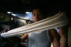 A worker tidies up the skeins of yarn before dyeing them. JP/Aditya Sagita