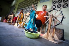 Women spin the yarn before putting it through the warping process. JP/Aditya Sagita