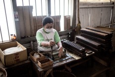 A worker cuts the ends of newly rolled cigars at the Rizona Baru cigar factory in Temanggung, Central Java. JP/Agung Parameswara