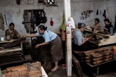 Women make cigars in one of the rooms in the Rizona Baru factory. JP/Agung Parameswara