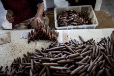 A man puts labels on the cigars in the Rizona Baru factory in Temanggung, Central Java. The factory was built in 1910 by Oo Tjong Han, a Chinese immigrant who lived in Temanggung. Every day the factory can produce 3,000 cigars, which are manually crafted by the skilled hands of the workers, who are mostly women. JP/Agung Parameswara

