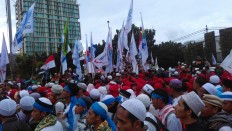 Workers demand both wage rise, arrest of Ahok