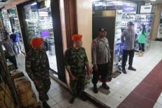 On alert: Military and police personnel stand guard at a Glodok shopping arcade in West Jakarta. Business activities ran as usual but shops were quieter than on typical days. JP/ Wendra Ajistyatama