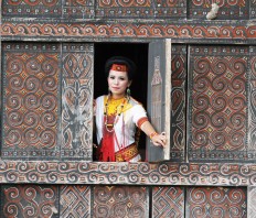 Opening up: A Torajan woman poses from inside a Tongkonan traditional house in Suloara’ village. JP/ PJ Leo