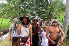  Ngedeblag participants carry sugar palm leaves, a symbol of the forest, as they march around Kemenuh village in Gianyar, Bali. JP/ Zul Trio Anggono