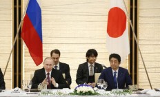 Japan, Russia sign economic pacts; stalemate on territory