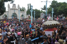 Hundreds of people struggle to obtain a piece of the gunungan, the cone shaped offerings, in front of the Surakarta Grand Mosque. JP/Ganug Nugroho Adi