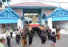 Royal servants and soldiers of the Kasunanan Palace, Surakarta, bring gunungan [cone shaped offerings], which contain vegetables, fruits, harvest yields and rengginang [sticky rice-based traditional snacks]. JP/Ganug Nugroho Adi