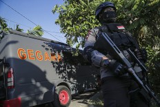 A full armed police is on guard on Dec.21, 2016, in an area leading to the house of a suspected terrorist in Batam, Riau Islands, during a raid conducted by personnel of the National Police’s Densus 88 counterterrorism squad.