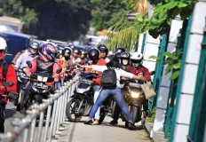 No way: Pedestrian Alfini, 34, boldly blocks motorcyclists trespassing on a sidewalk on Jl. Sudirman, Central Jakarta, on May 2.