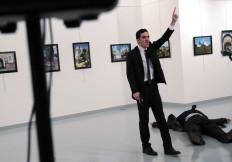 Mevlut Mert Altintas, an off -duty police offi cer, shouts after shooting Andrei Karlov [right], the Russian ambassador to Turkey, at an art gallery in Ankara on Dec. 19. Turkey’s president implicated a United States-based Muslim cleric in the killing of Russia’s envoy to Turkey, saying the policeman who carried out the attack was a member of his “terror organization”.
