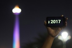 A visitor shows off the numbers 2017 on a smartphone during New Year’s Eve celebrations at Monas in Jakarta on Saturday evening. Antara/Rivan Awal Lingga