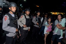 Fully armed police officers stand guard prior to New Year's celebrations at Kuta Beach in Bali on Saturday night. Antara/Fikri Yusuf