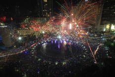 Thousand of Jakartans enjoy the fireworks at the Hotel Indonesia traffic circle in Jakarta on Saturday night. JP/Donny Fernando