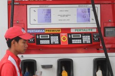 An attendant waits for a customer at a fuel station in Surakarta, Central Java.