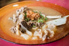 Enjoying a bowl of Makassar's local treat, 'sup konro'