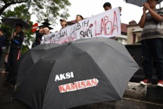 A Human rights activists in Malang, East Java, hold a Kamisan silent protest in front of City Hall to mark the 10th year of Kamisan events nationwide on Jan. 19. JP/Aman Rochman