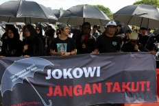 Activists participate in the 10th commemoration of the Kamisan silent protest in front of the Presidential Palace in Jakarta on Jan. 19. The 477th Kamisan marks the 10th year since the first protest in 2007 asking the government to resolve past human rights violations. JP/Seto Wardhana.
