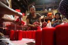 Abundant lights: Female workers prepare red candles for packaging. JP/ Donny Fernando