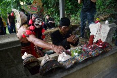 A dancer in Malangan mask costume prays in front of Mbah Karimun grave, Pakisaji, Malang, East Java late last month. JP/ Aman Rochman